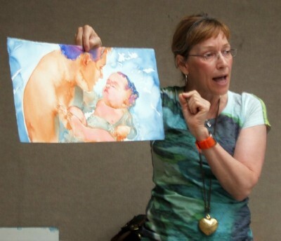 Carol poses with a work of parent holding a child just above water